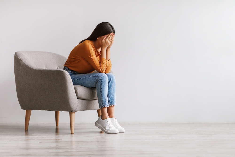 Woman sitting on couch worried